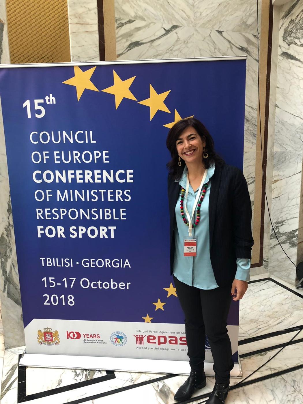 María José Rienda ante el cartel de la 15.ª Conferencia de Ministros del Deporte del Consejo de Europa